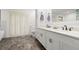 Stylish bathroom features double sinks, a large mirror, and shuttered windows for natural light at 1951 Downing Pl, Palm Harbor, FL 34683