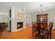 Dining area with a fireplace, hardwood floors, and a large dining table illuminated by a chandelier at 1951 Downing Pl, Palm Harbor, FL 34683