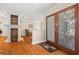 Foyer with wood floors, a decorative fireplace, and glass double doors that offers a glimpse into the living room at 1951 Downing Pl, Palm Harbor, FL 34683