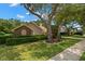 Quaint one-story home featuring lush front lawn and meticulous landscaping at 1951 Downing Pl, Palm Harbor, FL 34683