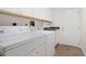 Bright laundry room featuring a washer, dryer, sink and a door to outside at 1951 Downing Pl, Palm Harbor, FL 34683