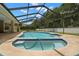 A Kidney-shaped pool with in-ground spa inside large screened enclosure at 1951 Downing Pl, Palm Harbor, FL 34683