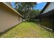 Side yard with grass between house and fence on sunny day at 1951 Downing Pl, Palm Harbor, FL 34683