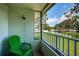 Enjoy the waterfront views from this screened balcony with green chair and view of pond at 2117 Lakewood Club S Dr # 7K, St Petersburg, FL 33712