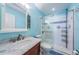 Bathroom with a sliding glass door shower, elegant vanity and blue decorative tile at 2117 Lakewood Club S Dr # 7K, St Petersburg, FL 33712