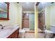Well-lit bathroom with a glass-enclosed shower, vanity with a mirror, and a toilet at 2117 Lakewood Club S Dr # 7K, St Petersburg, FL 33712