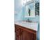 Bathroom with a wood vanity and marble top, white framed mirror and blue walls at 2117 Lakewood Club S Dr # 7K, St Petersburg, FL 33712