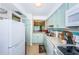 Charming kitchen featuring light blue cabinets, modern appliances, and an open view to the dining area at 2117 Lakewood Club S Dr # 7K, St Petersburg, FL 33712