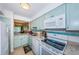 Well-lit kitchen boasts blue cabinets, stainless steel appliances, and a pass-through to the living room at 2117 Lakewood Club S Dr # 7K, St Petersburg, FL 33712