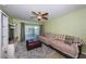 Bright living room featuring a large sectional couch, ceiling fan, and balcony access at 2117 Lakewood Club S Dr # 7K, St Petersburg, FL 33712