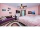 Serene bedroom featuring soft pink walls, a ceiling fan, and comfortable furnishings at 2117 Lakewood Club S Dr # 7K, St Petersburg, FL 33712