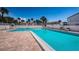 Large in-ground pool surrounded by lounge chairs and palm trees on a sunny day at 2117 Lakewood Club S Dr # 7K, St Petersburg, FL 33712