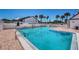 A clear and refreshing swimming pool with lounge chairs surrounded by a fence and palm trees at 2117 Lakewood Club S Dr # 7K, St Petersburg, FL 33712