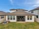 Rear exterior view of the home with a screened-in patio and well-kept lawn at 22294 Storybook Cabin Way, Land O Lakes, FL 34637