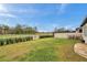 Well-maintained backyard featuring a white fence, green lawn, and view of the surrounding landscape at 22294 Storybook Cabin Way, Land O Lakes, FL 34637