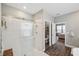 Bright bathroom featuring glass enclosed shower, tiled walls, and wood look floors at 22294 Storybook Cabin Way, Land O Lakes, FL 34637