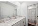 Bright bathroom featuring double vanity, framed mirror, and a view into the shower at 22294 Storybook Cabin Way, Land O Lakes, FL 34637