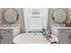 Bright bathroom features a soaking tub, double vanity, decorative mirrors and light fixtures at 22294 Storybook Cabin Way, Land O Lakes, FL 34637