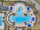 Aerial view of a sprawling community pool area with pools, waterslides, cabanas, and palm trees at 22294 Storybook Cabin Way, Land O Lakes, FL 34637
