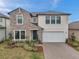 Charming two-story home featuring stone accents, a two-car garage, and a beautifully landscaped front yard at 22294 Storybook Cabin Way, Land O Lakes, FL 34637