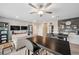 Spacious living room with neutral colors, bookshelves, TVs, tables, and a comfortable sofa at 22294 Storybook Cabin Way, Land O Lakes, FL 34637
