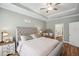 Stylish bedroom with a tufted headboard, neutral decor, and access to the bathroom at 22294 Storybook Cabin Way, Land O Lakes, FL 34637