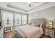 Tranquil bedroom with a tufted headboard, tray ceiling, and lots of natural light from the windows at 22294 Storybook Cabin Way, Land O Lakes, FL 34637