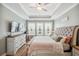 Bright and spacious bedroom with a tufted headboard, tray ceiling, and natural light at 22294 Storybook Cabin Way, Land O Lakes, FL 34637