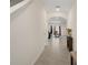 Well-lit hallway with tile flooring leading to a living space at 2449 Moon Shadow Rd, New Port Richey, FL 34655