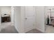 Hallway featuring a closed storage door, a view into a room, and carpeted flooring at 2449 Moon Shadow Rd, New Port Richey, FL 34655