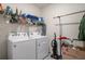 Well-equipped laundry room with a washer, dryer, shelving and other supplies at 2449 Moon Shadow Rd, New Port Richey, FL 34655
