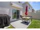 Back patio with a barbecue, sliding glass doors, patio table and chairs, and green grass perfect for relaxing and entertaining at 2449 Moon Shadow Rd, New Port Richey, FL 34655