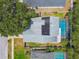 Aerial view of home with solar panels, screened-in pool, and lush landscaping at 2667 Aspen Ct, Palm Harbor, FL 34684