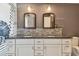 Modern bathroom featuring a double vanity, granite counters, and decorative mirrors at 2667 Aspen Ct, Palm Harbor, FL 34684