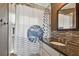 Close up of a modern bathroom featuring a vanity with sink and shower with patterned curtain at 2667 Aspen Ct, Palm Harbor, FL 34684