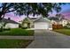 Beautiful single-Gathering home featuring a two-car garage, manicured lawn, and serene twilight sky backdrop at 2667 Aspen Ct, Palm Harbor, FL 34684