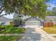 Charming home featuring a well-manicured lawn, lush landscaping, and a two-car garage at 2667 Aspen Ct, Palm Harbor, FL 34684