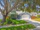 Charming home featuring a well-manicured lawn, lush landscaping, and a two-car garage at 2667 Aspen Ct, Palm Harbor, FL 34684