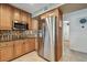 Stainless steel refrigerator stands tall next to a chef's kitchen in this home at 2667 Aspen Ct, Palm Harbor, FL 34684
