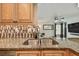 Kitchen sink with granite countertop, tile backsplash, and open view to the living room at 2667 Aspen Ct, Palm Harbor, FL 34684