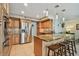 Modern kitchen with stainless steel appliances, granite countertops, tiled floor, and breakfast bar seating at 2667 Aspen Ct, Palm Harbor, FL 34684