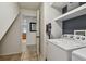 Bright laundry room features a modern washer, dryer, storage shelves, and convenient vacuum storage at 2667 Aspen Ct, Palm Harbor, FL 34684