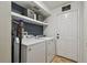 Laundry room with washer, dryer, and storage shelves in a functional space at 2667 Aspen Ct, Palm Harbor, FL 34684