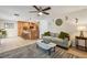 Open-concept living room with a gray sofa, ceiling fan, and adjacent kitchen area at 2667 Aspen Ct, Palm Harbor, FL 34684