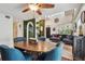 Bright living and dining area with blue chairs, ceiling fan, staircase, and comfortable seating at 2667 Aspen Ct, Palm Harbor, FL 34684