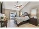 Cozy bedroom with a ceiling fan, tile flooring, sliding glass doors to the patio, and closet space at 2667 Aspen Ct, Palm Harbor, FL 34684
