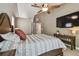 Comfortable main bedroom featuring a ceiling fan, television, and stylish decor at 2667 Aspen Ct, Palm Harbor, FL 34684