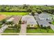 Aerial shot of a one-story home, well-manicured lawn and tropical landscaping with palm trees in the front yard at 2973 Breezy Meadows, Clearwater, FL 33760