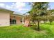 Home backyard featuring a wooden playset, ceiling fan covered patio, and lush lawn at 2973 Breezy Meadows, Clearwater, FL 33760