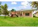 Backyard featuring a wooden playset, lush lawn, and view of the covered patio at 2973 Breezy Meadows, Clearwater, FL 33760